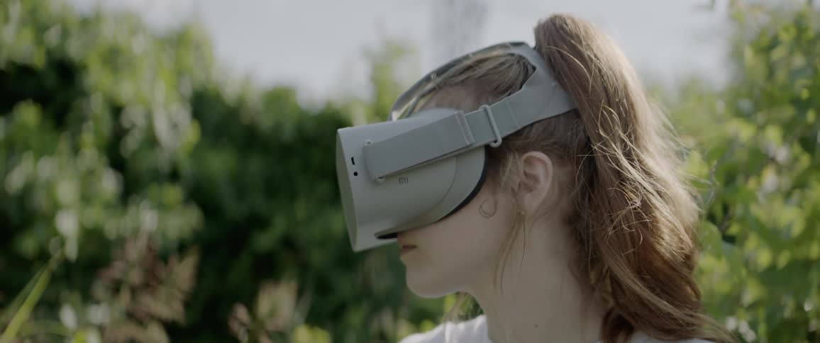 A young girl wearing virtual reality glasses looks around