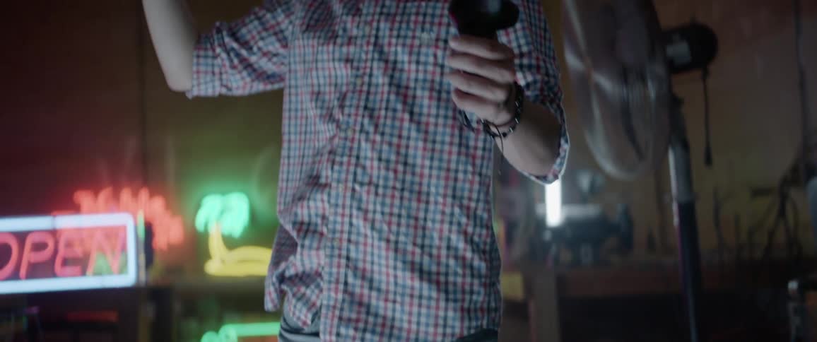A man stands holding items in his hands