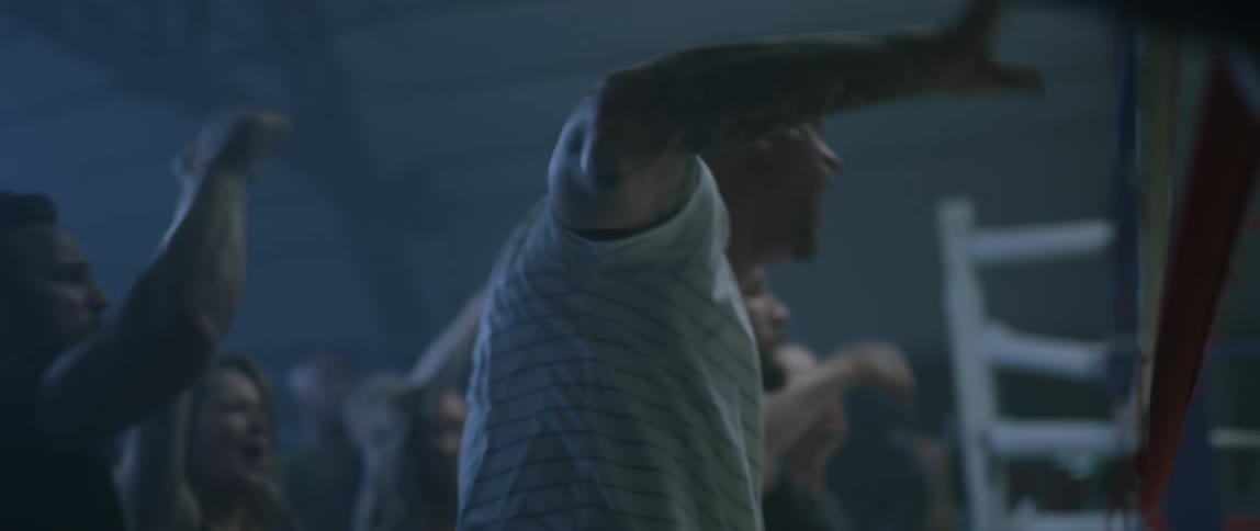 An audience cheers on a boxing match