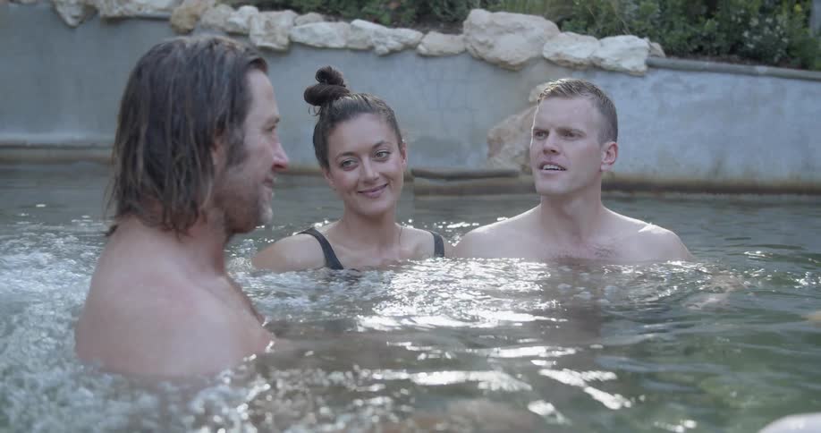 Friends relaxing and talking while bathing on a hot water pool