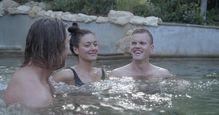 Three people relaxing and laughing in a jacuzzi