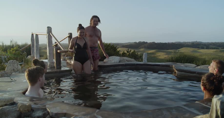 Couple stepping into a hot spring at spa resort
