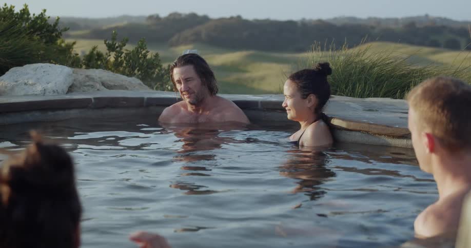 Man sitting with others in outdoor pool talks