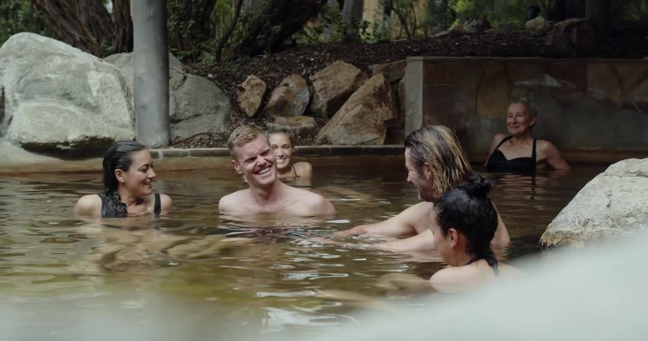 Six people are talking and laughing in an outdoor pool