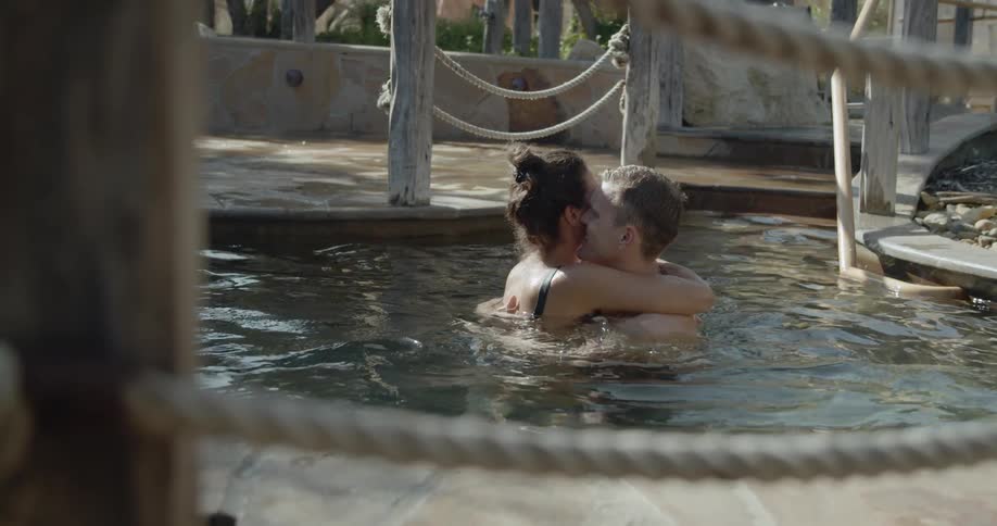 A couple embrace in an outdoor hot tub together