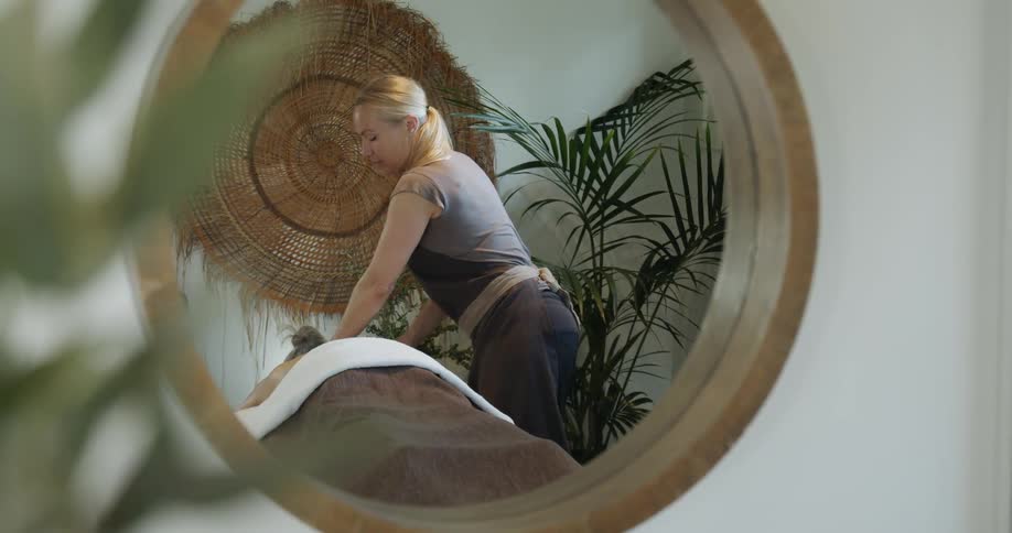 Female masseuse massaging a client at a spa