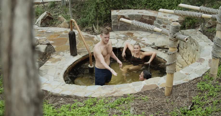 A man joins two women in a bath spa pool
