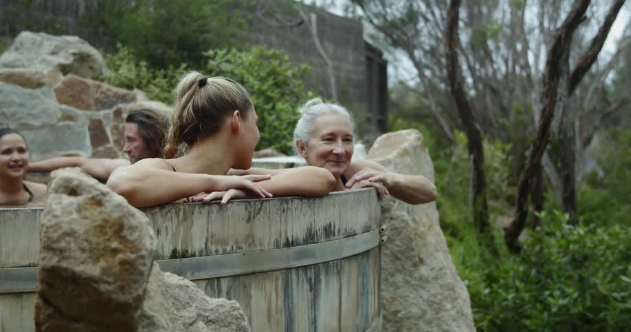 People stilling in a wooden hot hub