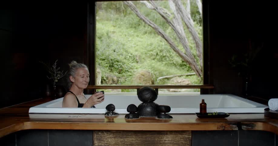 A woman takes a bath and drinks in the spa center