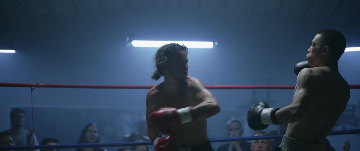 Two men boxing in front of a crowd