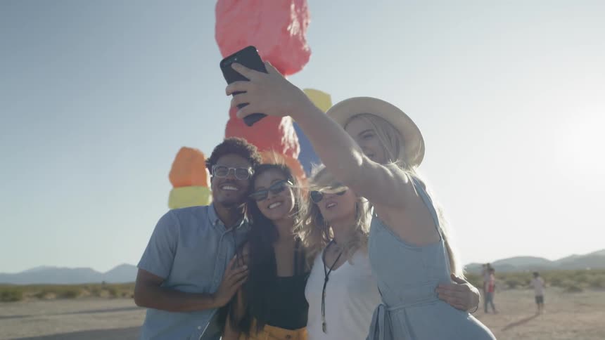 Friends taking a photos with large color rocks