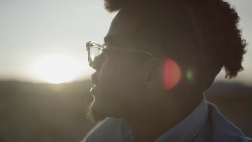 A young black man looks off in to the distance