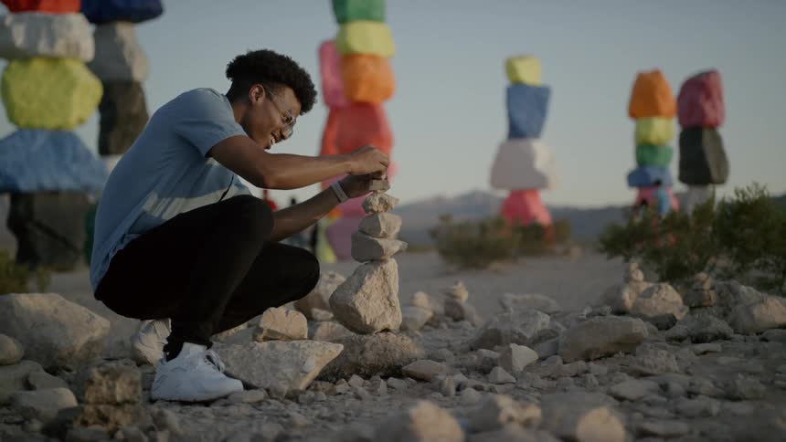 A man is stacking rocks on the trail