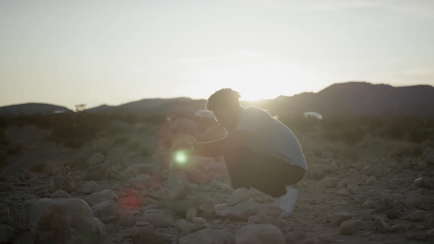A man picking up a rock