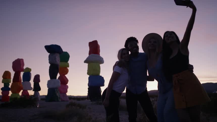 A group of people taking a photo in front of a monument at dusk