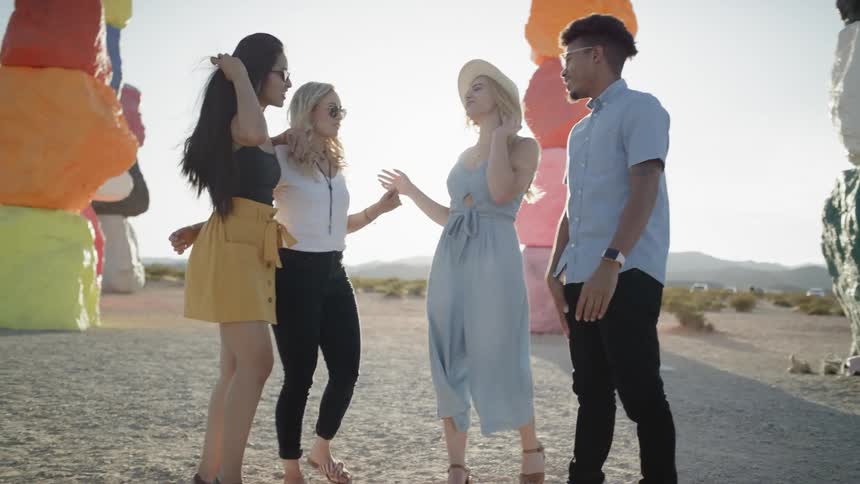 Four friends hang out in between sculptures