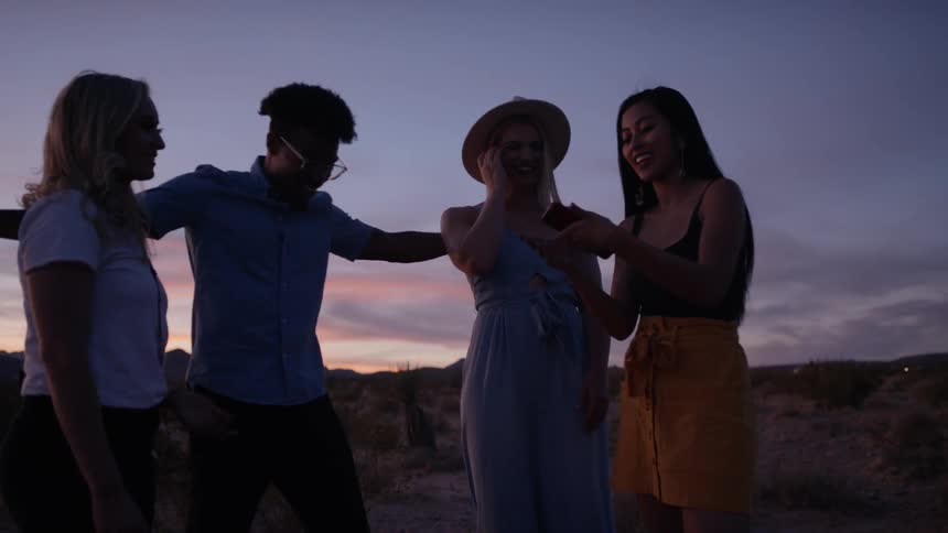 A group of people are outdoors having fun at dusk