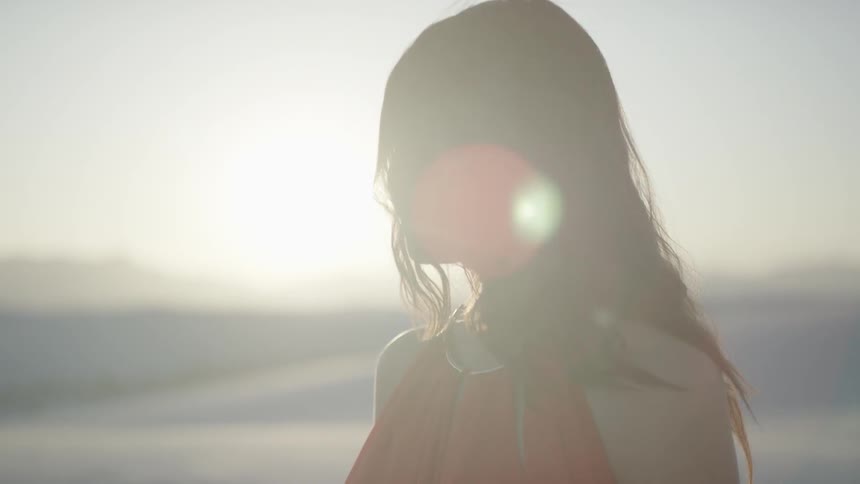 A young woman stands on a beach