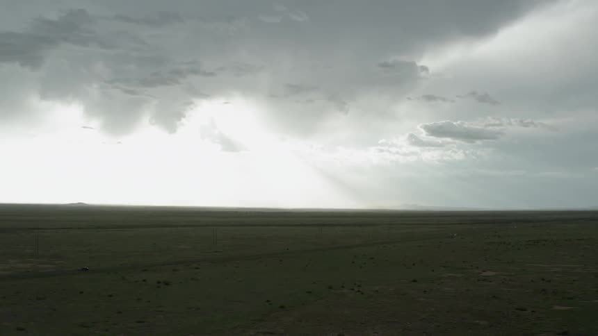 Ariel view of arid land and road with cars driving on a cloudy day