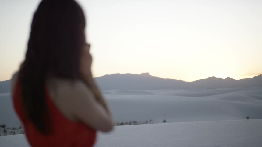 A woman takes a photo of the desert with her camera