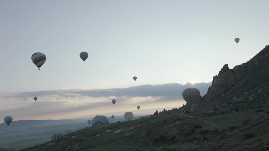 Hot air balloons rising from a rocky terrain