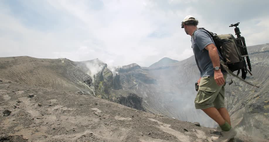 A photographer hikes near a volcano