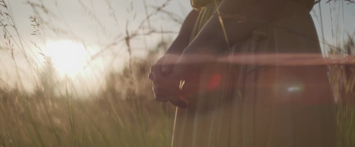 A woman stands in the tall grass