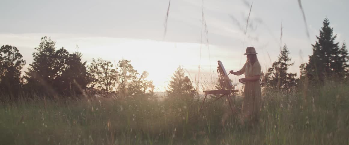 An artist paints in a meadow