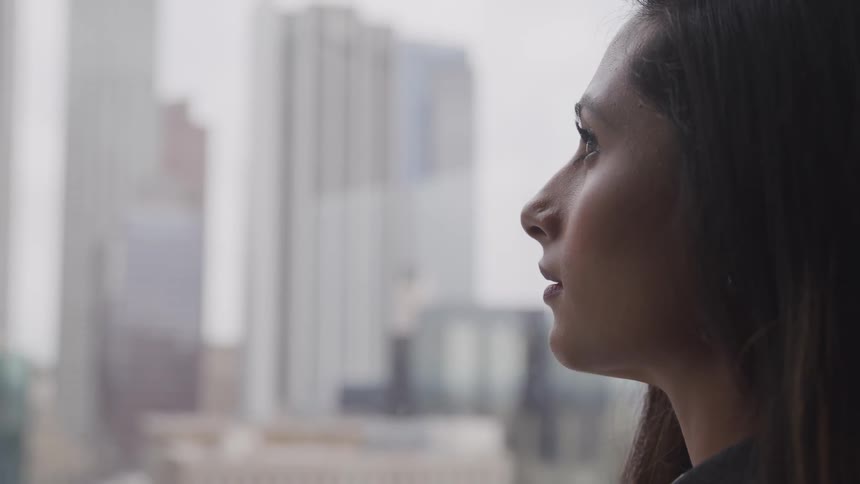 Businesswoman looks out the window in the office