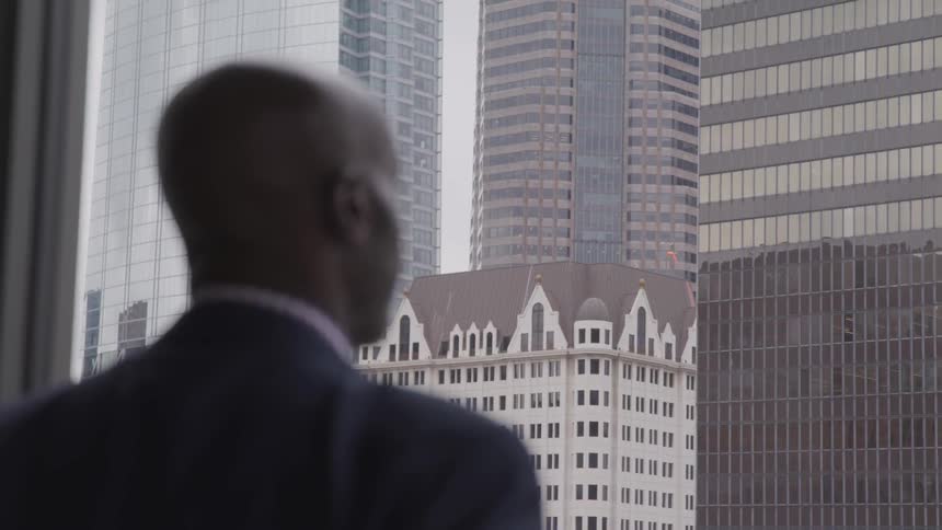 A black man stare to outside of the window