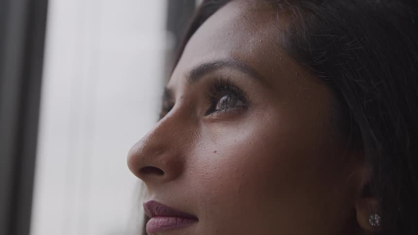 Brunette business woman looks up out the window in the office