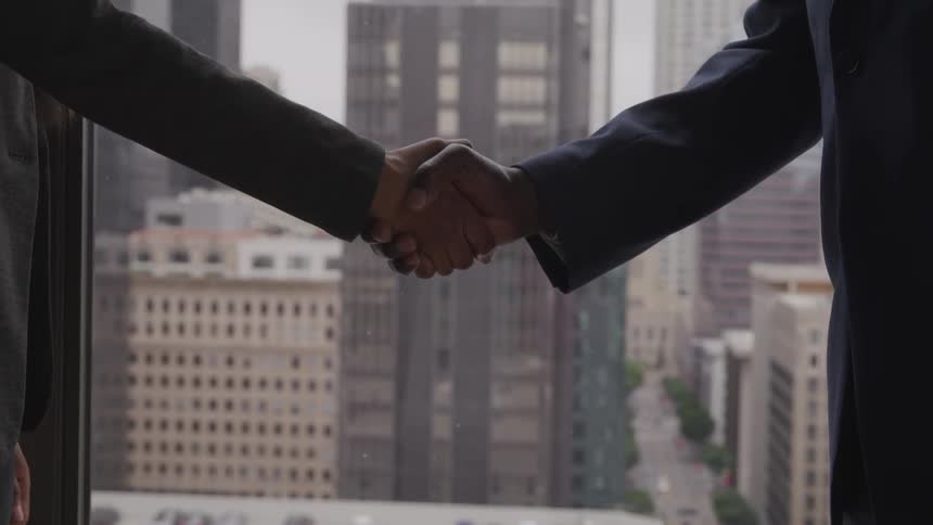 Two men shake hands