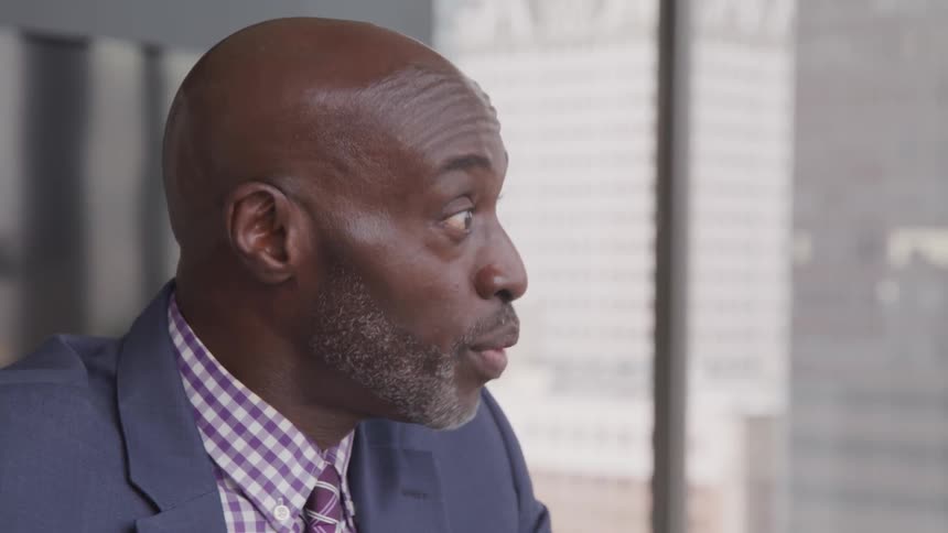 A black man with suit talks with the client