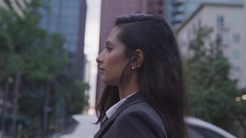 Business woman walks down the street at dusk in the city