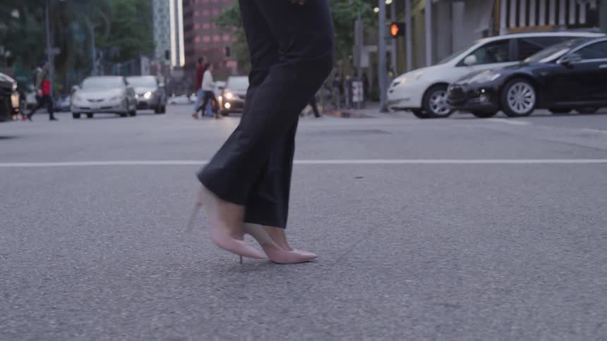 A woman is walking on a street in the city