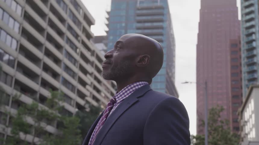 A man with suit stand in the middle of city