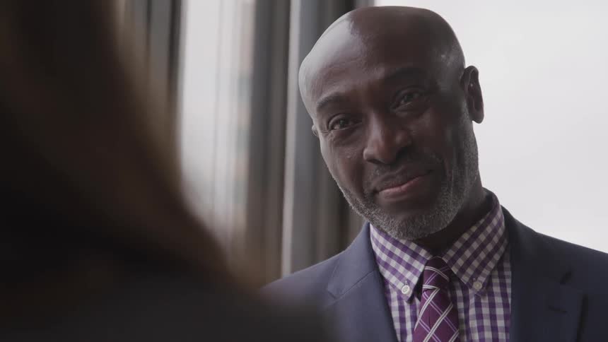 A man is smiling and talking to someone