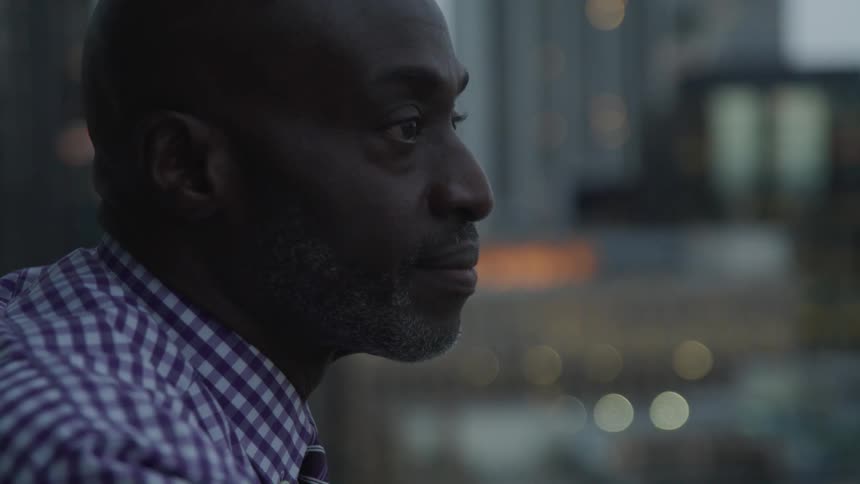 A black man contemplatively thinking