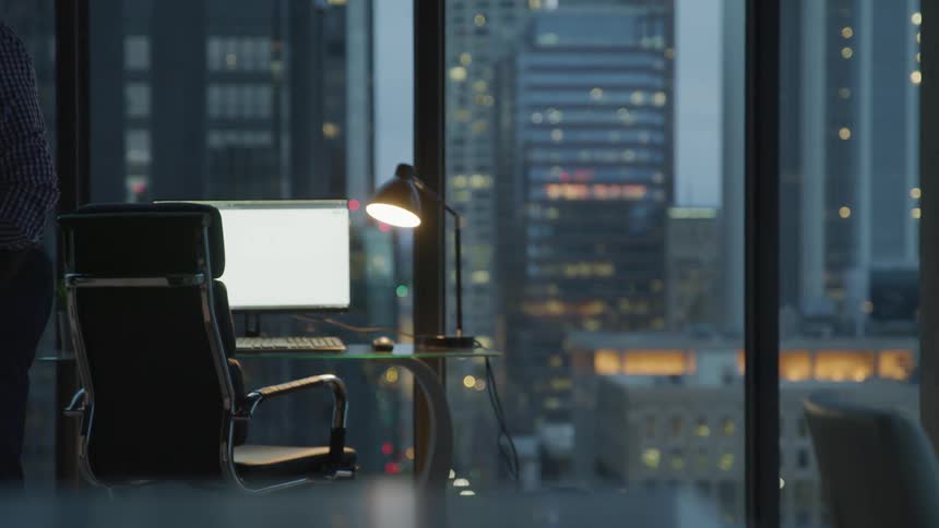 Businessman walks in the office at dusk