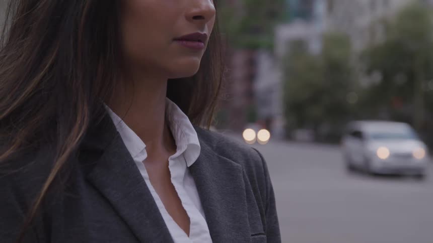 Woman stands near busy city street during the day