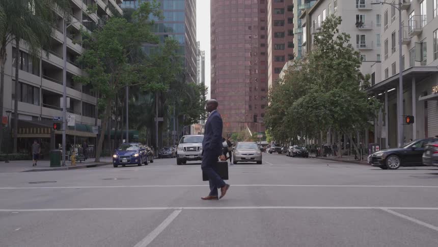 Man in suit crosses street in downtown