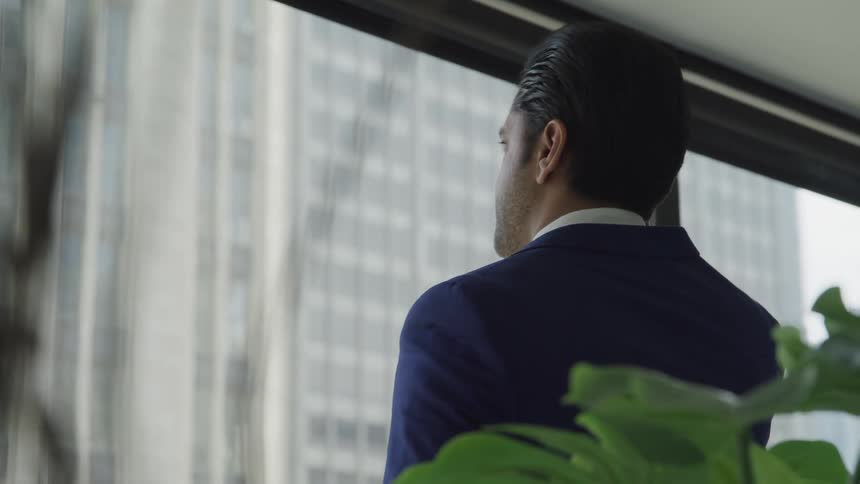 A man looking trough the window from the office