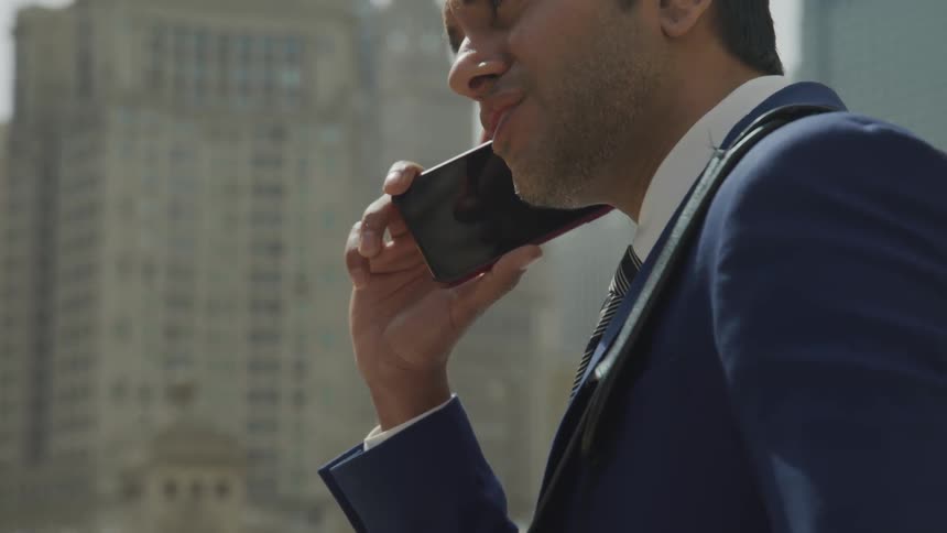 A young man talks on his cell phone in his office
