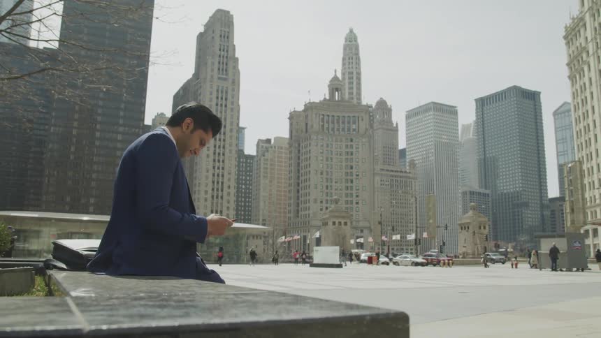 A man sits on a bench in the city