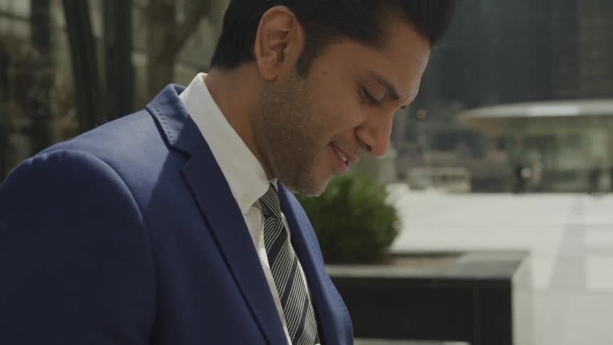 A young man looks down and smiles