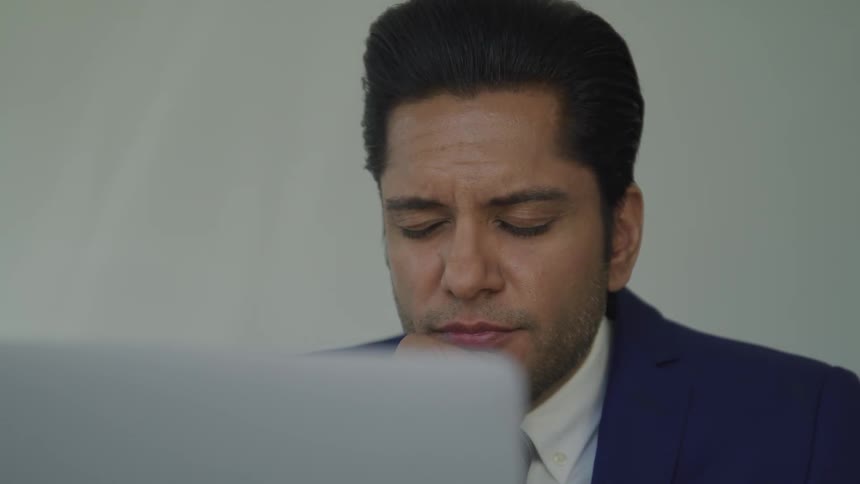 A man closes his eyes at the computer
