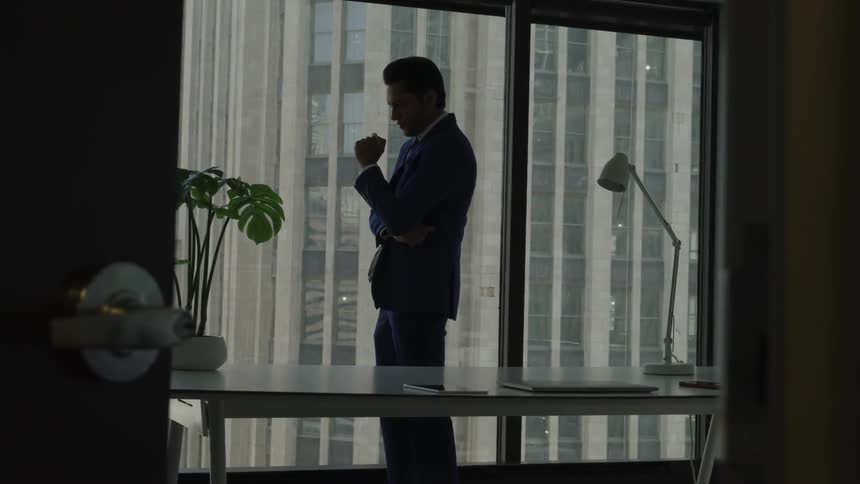 A man with suit contemplatively thinking in the office room