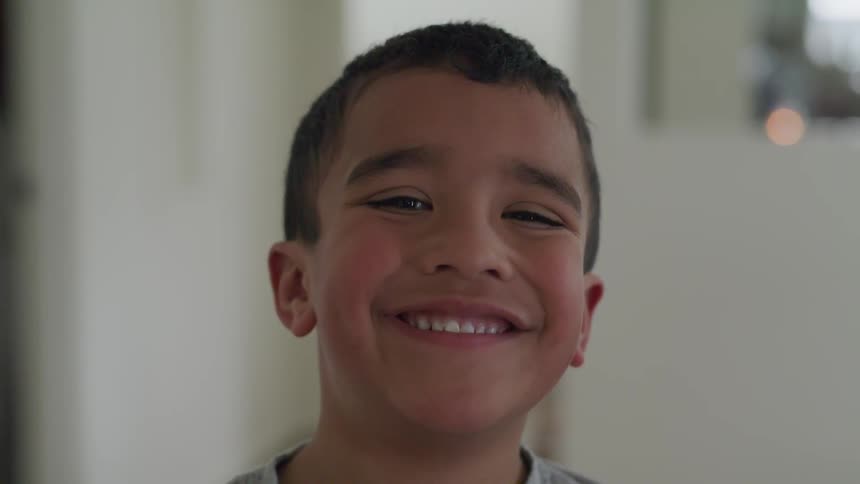 A hispanic child smiles broadly