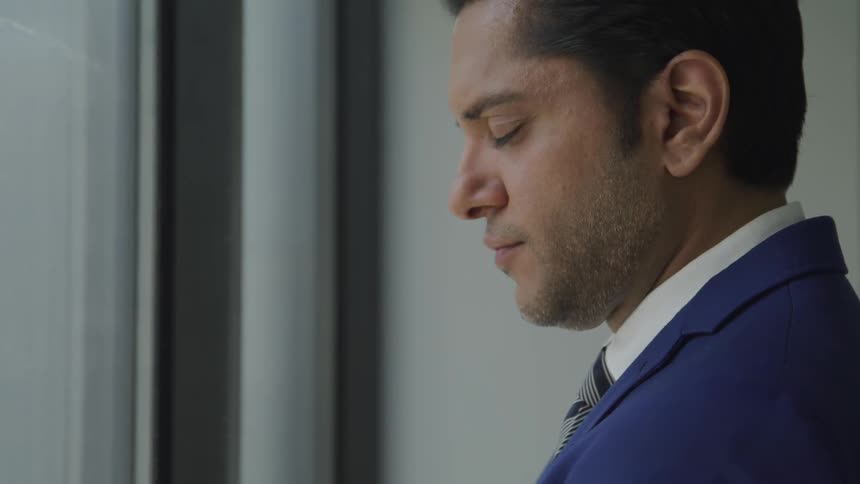 A man in a suit looking down