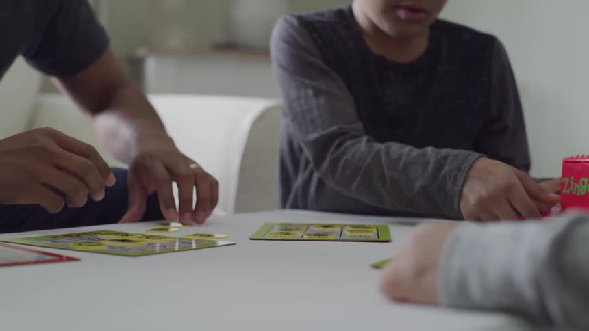 Three boys sit and play a game together